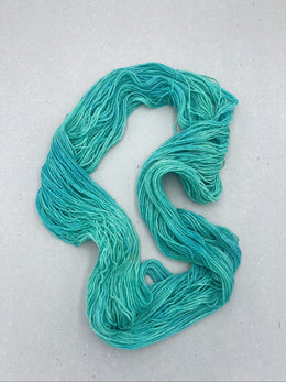 Turquoise yarn skein on a light gray background